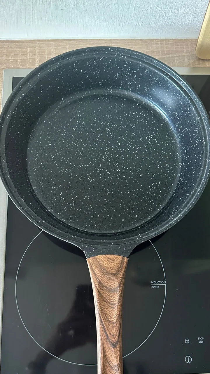 Kundenfoto: schwarze Pfanne von oben auf einem Induktionskochfeld.