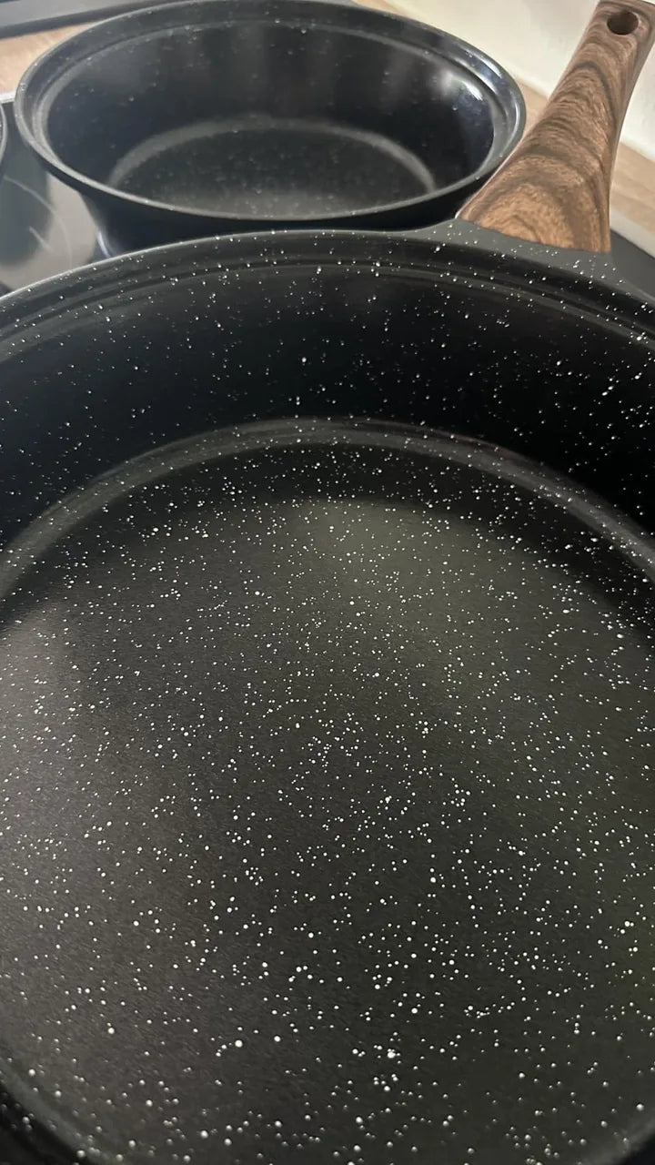 Kundenfoto: Innenfläche einer schwarzen Pfanne aus der Nähe, dahinter eine weitere Pfanne.
